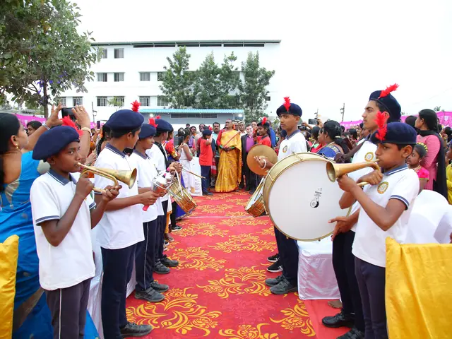 Two rows of student band members in red-plumed berets play drums and bugles along a red carpet