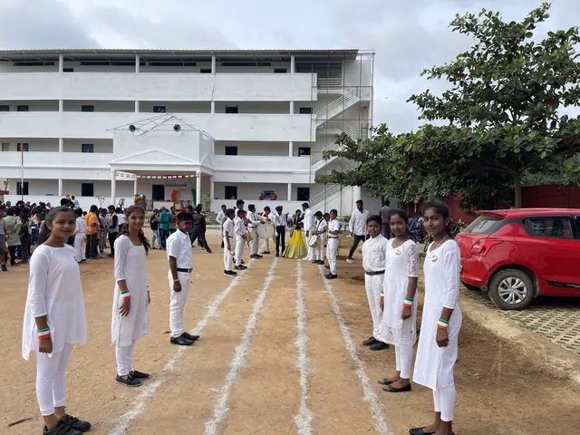 The long white three-storey school block with children in formation in front, morning light