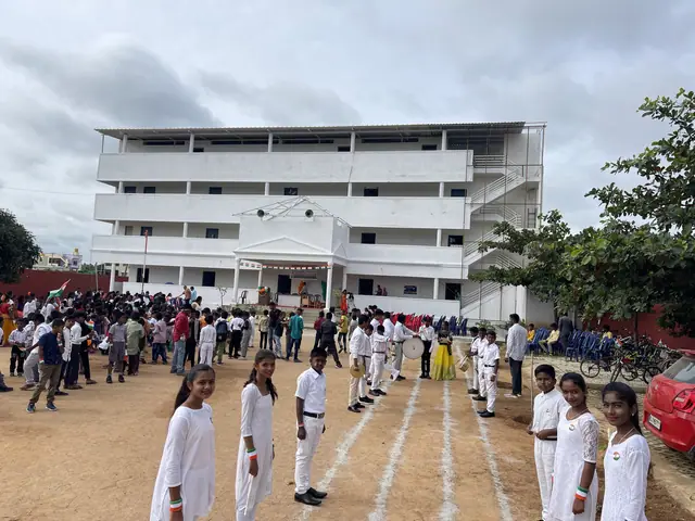 Frontal view of the three-storey school building with rows of children lined up before it