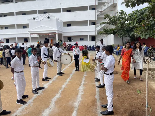 March-past on the school ground: senior students in white with drums parading past teachers