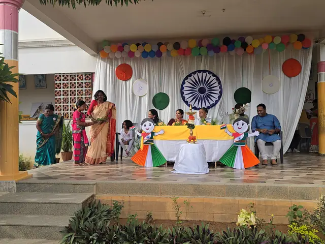 The school verandah stage with white drapes and chakra backdrop, guests seated at a decorated table