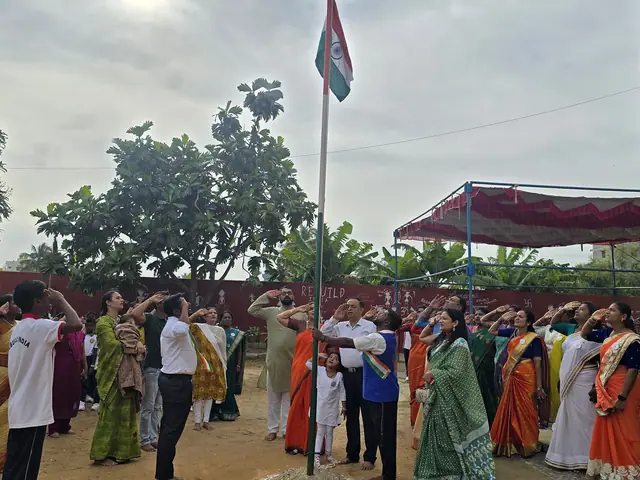 Crowd of adults and students at the base of the flagpole with the tricolour raised