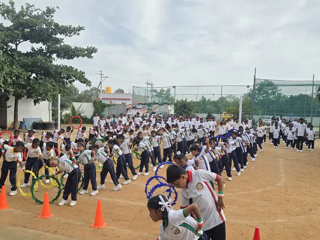 Long converging lines of students in white uniforms between orange cones on the school ground