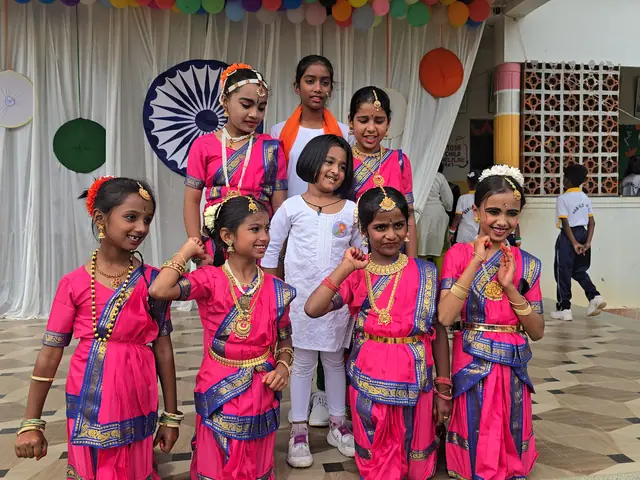 Girls in pink and white raising hands in a salute-like pose, faces clearly visible