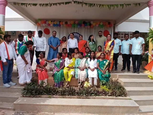 Rows of adults in sashes standing behind children in coloured dresses on the decorated stage