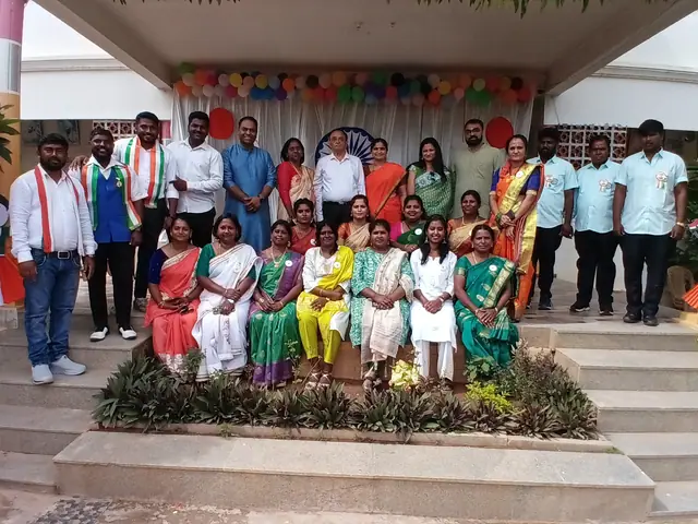 Staff and children posed together on the stage steps with hedges in the foreground