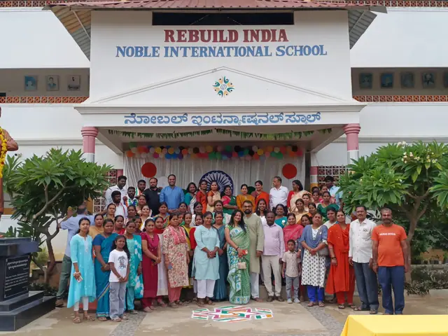 Full frontal view of the school building with its name board and the garlanded statue on its plinth