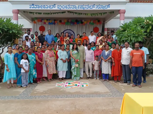 A group weighted towards women in saris in front of the school portico