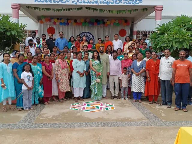 Many women and a few men in orange shirts standing shoulder to shoulder, rangoli on the paving