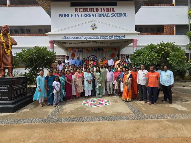 Community group in front of the school with volunteers in orange shirts through the line