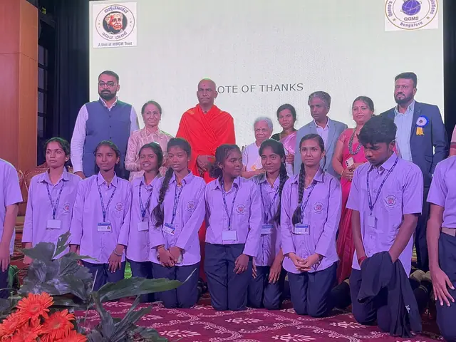 School children in lilac uniforms with ID lanyards in neat rows on the auditorium stage