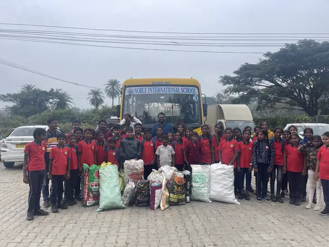 The whole school lined up in front of a yellow bus behind a row of donated grain sacks and relief goods