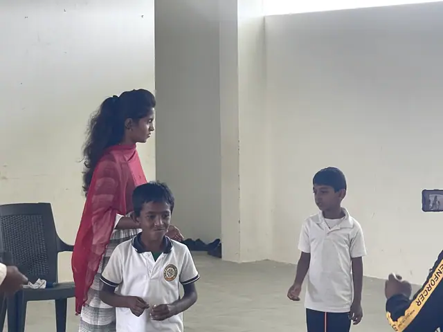 A small boy smiling straight at the camera holding his prize, a woman beside him