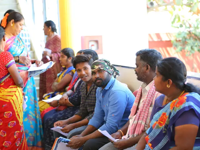 A long row of villagers sit in the waiting line reading their forms, colour-rich and layered