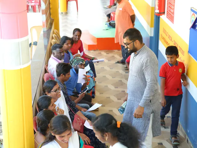 Children and adults along a corridor of bright yellow, red and blue painted columns inside the school